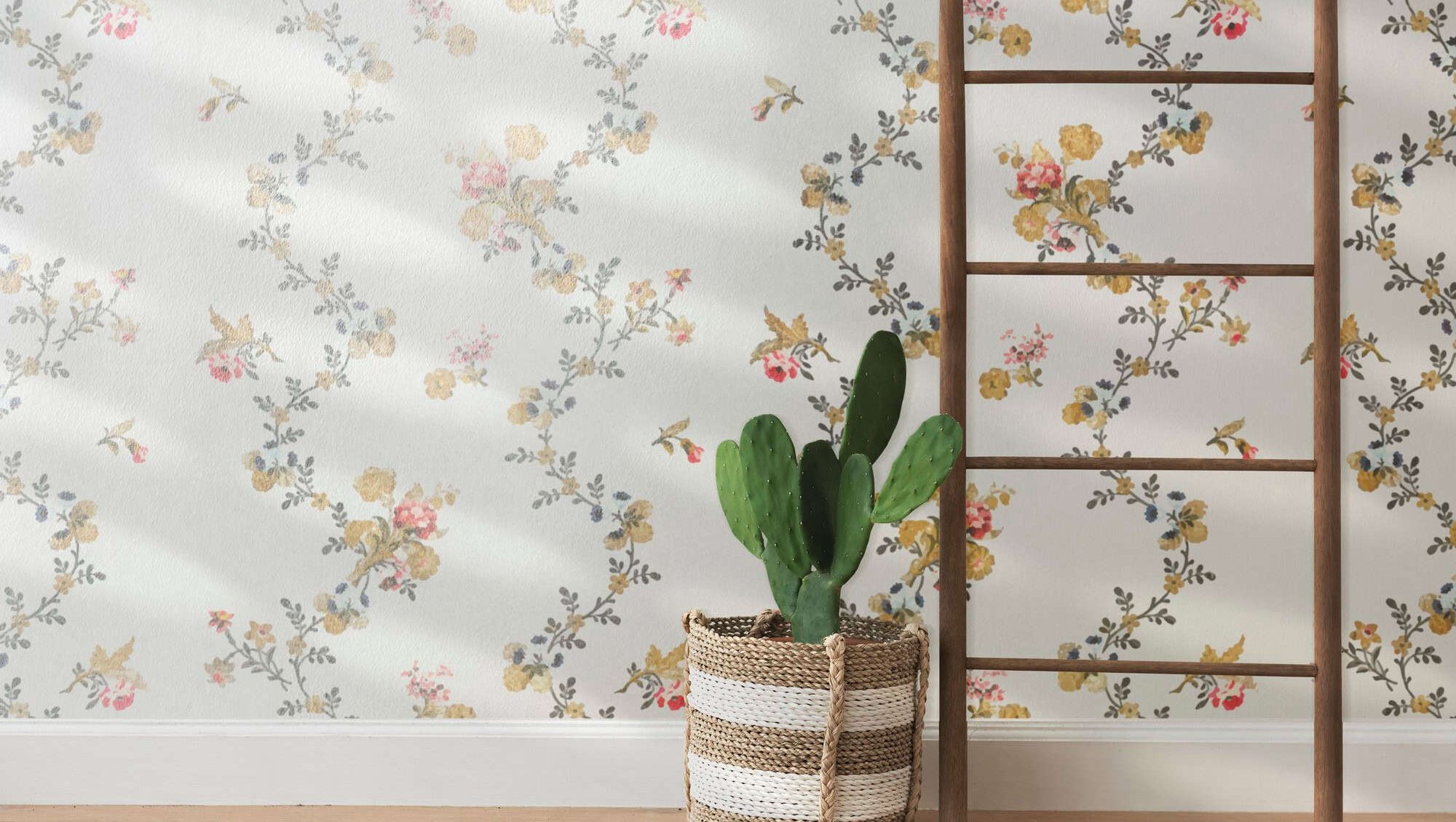 Vegg med blomstrete tapet, kurvplante og trestige i interiør.